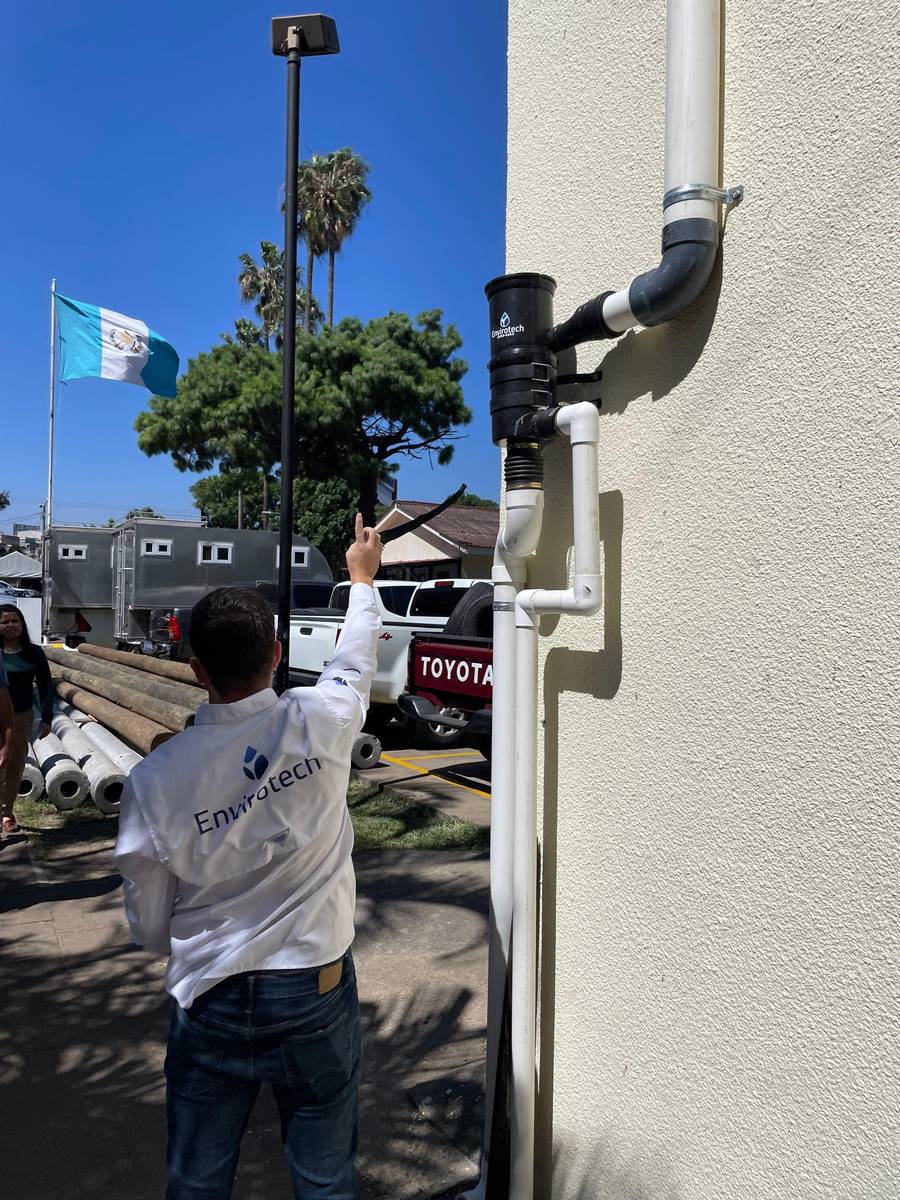 Técnico de Envirotech revisando un filtro de captación de agua de lluvia instalado en una bajada pluvial